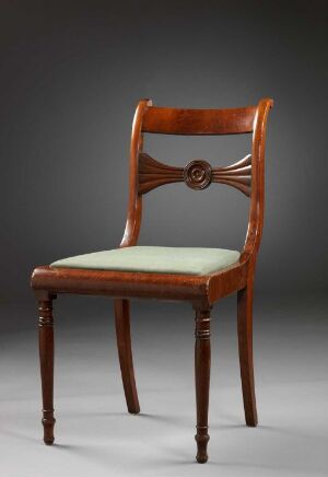  Elegant traditional wooden chair with a brown frame, featuring a decorative carved detail on the backrest, and a pale olive-green upholstered seat against a gradient gray background.