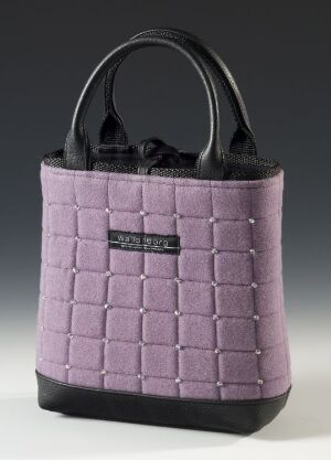  A pastel purple, quilted-pattern tote handbag with smooth black handles and a small black label on the front, set against a neutral gray background.