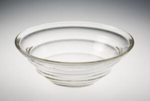  A clear glass bowl by Hadeland Glassverk with a simple, elegant design featuring concentric circles, creating a layered band effect, set against a light grey background.