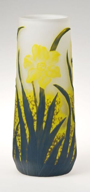  A tall white cylindrical vase painted with a vibrant yellow flower and green leaves, displaying spontaneous brush strokes suggestive of a wildflower meadow.