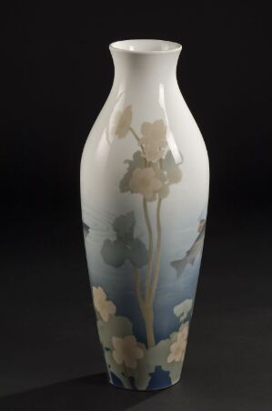  A tall, slender porcelain vase by Porsgrunds Porselænsfabrik AS with a soft blue and white gradient background featuring hand-painted underglaze decor of beige and soft blue flowers and foliage, against a dark backdrop that emphasizes its elegant form and artistic detailing.