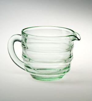  "Sola" - a delicate press glass cup with concentric bands designed by Sverre Pettersen, featuring a smooth handle with an elegant curl on top against a neutral background, in translucent pale green color.