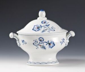  A white feldspar porcelain covered dish with hand-painted cobalt blue floral and foliage motifs, designed by Hans Flygenring. The dish has symmetrically placed handles and a decorative blue knob on the lid. The base is detailed with a blue scalloped trim.