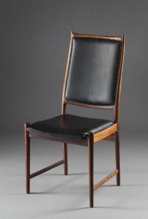  A "Darby" chair by designer Torbjørn Afdal, featuring varnished reddish-brown palisander wood and black leather upholstery, set against a neutral gray background.