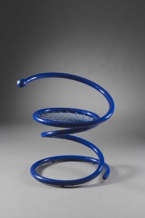  A Peter Opsvik-designed chair made of blue, lacquered metal spirals coiling upwards from the floor, creating an artistic and functional sitting design against a neutral background.