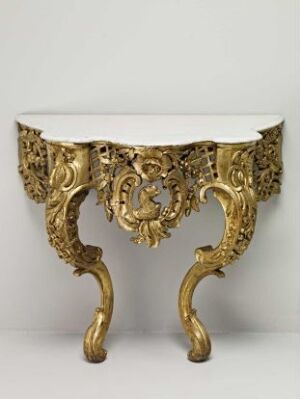  An ornate gilded console table with a white marble top and intricate gold scrolling and leaf motifs on its base and legs.