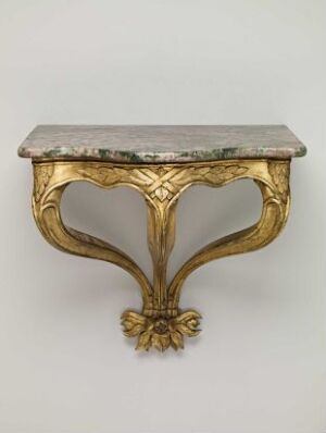  An antique gilded console table with a weathered marble top, featuring intricate carvings of acanthus leaves and a central floral motif, conveying a sense of classic elegance.