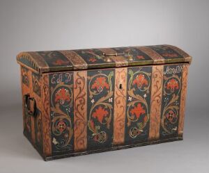  An antique wooden storage chest with a domed lid, hand-painted with intricate red, orange, green, and gold floral and scrollwork patterns on a black or dark brown background, featuring metal handles and latch.