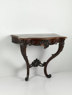  Antique dark wood table with elaborate leg carvings and a polished finish against a plain off-white background.