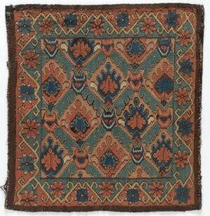  An antique square textile featuring intricate geometric and floral patterns in deep teal, rust-orange, slate blue, and beige, showcasing expert craftsmanship and a rich cultural heritage in textile art.