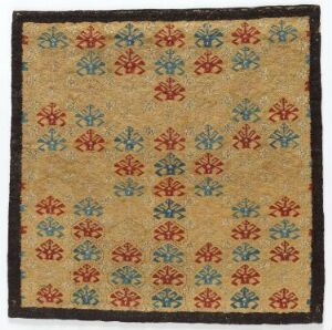  A handwoven tapestry titled "Skybragd" by an unknown artist, featuring a pattern of alternating red and blue eight-petal flower motifs on a warm beige background, framed by a dark border.