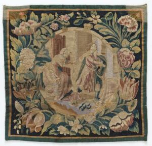  An antique square tapestry with a central classical scene surrounded by a detailed floral border in muted earth tones, featuring two female figures within an oval vignette and an array of naturalistic flowers including roses and lilies.