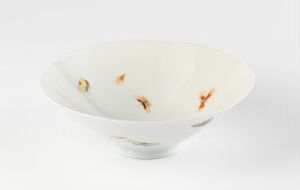  A shallow, translucent off-white ceramic bowl with delicate paintings of orange and red goldfish inside, set against a white background. The bowl has a sheen suggesting a porcelain material, and the artistry of the fish conveys a sense of motion within the calm and simple elegance of the bowl.