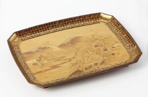  An octagonal golden tray with detailed traditional East Asian landscape engravings in the center surrounded by a decorative motif on the raised edges.