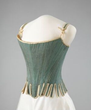  A 19th-century style corset in pale mint-green with vertical darker green stripes, adorned with golden grommets and chains on a white mannequin against a light grey background.