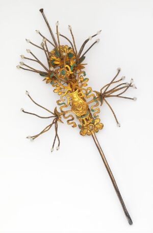  An ornate, golden floral hairpin or brooch with delicate, radiating stems in a darker tone against a white background.