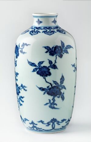  A traditional Chinese blue and white porcelain vase with intricate floral patterns and a flared rim, set against a plain, light background.