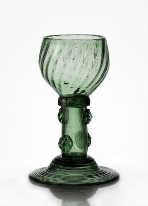  A translucent emerald green glass goblet with a conical base, a spiraling dimple pattern on the bowl, and decorative knops on the stem. The elegant goblet suggests craftsmanship reminiscent of historical glass-blown artistry.