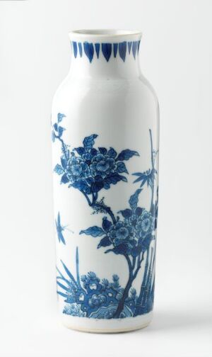  A tall, slender porcelain vase with a glossy surface, featuring intricate blue floral patterns on a white background. Artistname and title are unknown.