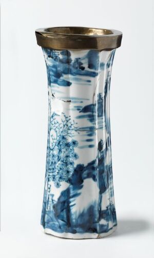  An elegant porcelain vase with a gold-trimmed rim and a detailed blue and white oriental-style pattern, featuring floral or arboreal elements, against a plain white background.