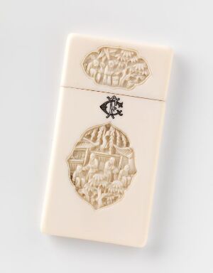  A cream-colored, rectangular game piece with intricate carvings, likely from a Mahjong set, standing upright against a light grey background showing a detailed embossed scene and a symbol on its upper section.