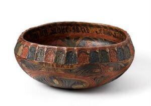  A round, hand-crafted earthenware bowl with a textured terra-cotta base, decorated with patterns in ochre, smoky gray, and black, featuring text or symbols along its upper rim.