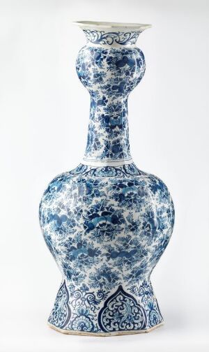  A tall, intricately patterned porcelain vase with a slim neck and bulbous body, adorned with cobalt blue floral and abstract motifs on a white background.