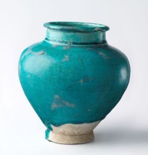  A glossy teal-colored spherical vase with a narrow opening, sitting against a neutral background.