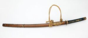  An antique curved sword with a brown scabbard and a blue and black wrapped handle, featuring golden metal accents, displayed against a light background.