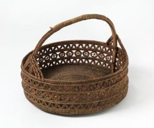  A handcrafted oval basket with intricate woven patterns and a sturdy handle, exhibiting natural shades of brown, showcasing the art of traditional basketry.