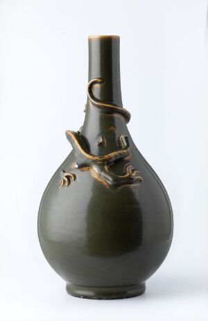  A dark green glossy ceramic vase with a slender neck and bulbous base, featuring a metallic-lustered handle and ornamental accents, presented against a white background.