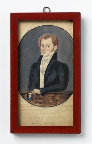  A vintage gouache painting on paper by A. Bull titled "Johann Ludolph Schladermund holder sin Hustrus Portræt (daarlig malt)," depicting a reserved gentleman with wavy brown hair and a dark coat, holding a small, poorly detailed portrait of a woman on a wooden table, all framed within a vibrant red wooden frame.