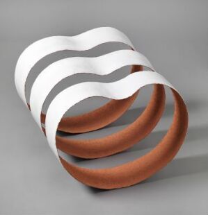  "Nr 42" by artist Beth Wyller, a hand-modeled and glazed terracotta decorative object with a twisting ribbon-like form. Warm reddish-brown terracotta contrasts with white glazed bands, creating a striking visual rhythm.