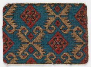  An antique textile featuring a vibrant turquoise background with repeating geometric patterns, including crimson red and navy blue diamonds accented with sandy beige. The design has a traditional feel, possibly of Central Asian or Middle Eastern origin.