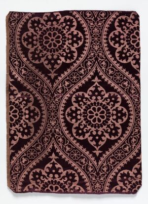  Intricate maroon and dark patterned textile, possibly vintage, with symmetrical floral and swirling motifs suggesting a traditional brocade or tapestry design.