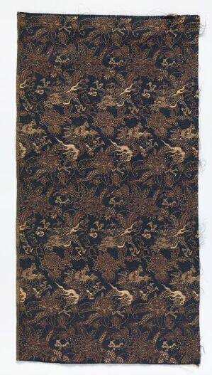  A detailed image of a dark brown or black textile with a gold, light brown, and beige ornamental and floral repetition pattern that gives a sense of historical luxury and craftsmanship.