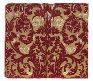  An image of a luxurious gold and burgundy damask pattern with symmetrical floral motifs and intricate swirling tendrils.