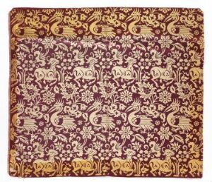  Intricate, symmetrical golden and cream floral and paisley patterns over a deep maroon textile, displaying a sense of traditional opulence and luxury.