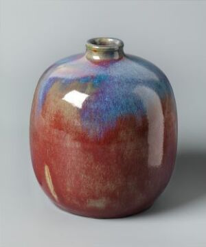  A spherical ceramic vase with a glossy glaze featuring a gradient from terracotta at the bottom to cobalt blue and purple at the top, displayed against a neutral gray background.