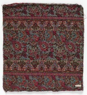  An intricately designed square textile with rich maroon as the base color, adorned with detailed repeating patterns in shades of green, indigo, ivory, and pale salmon. The textile has frayed edges, suggesting age or use. Artist name and title are unknown.