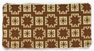  A rectangular textile featuring a repetitive geometric pattern with square and star shapes in shades of dark brown, light tan, and cream.