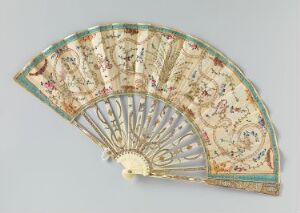  An intricately designed fan, with a cream-colored background showcasing floral motifs, bordered by a sky blue edge with gold patterns; the fan's carved ribs appear to be of bone or ivory, radiating outwards from a circular base.