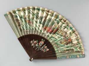  A traditional East Asian folding fan with a dark handle adorned with a pink and green floral design. The fan has light wooden ribs with green stripes and features a painted scene of figures in colorful traditional costumes among trees and flowers on an off-white background.