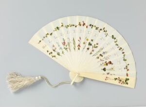  An opened decorative folding fan with an off-white fabric and a cream-colored tassel, featuring a spread of small painted figures in various colors and activities on its surface.