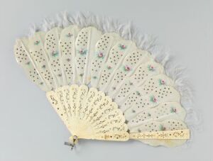  An antique ivory-colored hand fan with intricate piercings and painted flowers in soft blue, pink, and green, adorned with a border of white ostrich feathers against a neutral gray background.