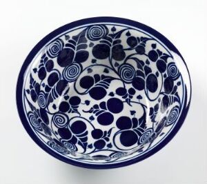  A ceramic bowl with an intricate cobalt blue floral and swirl pattern on a white background, showcasing traditional porcelain glazing and a symmetrical design.