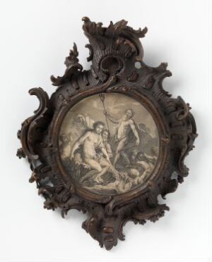  An ornate, dark-colored wooden frame with intricate carvings surrounding an oval central relief depicting three figures in a dynamic interaction.