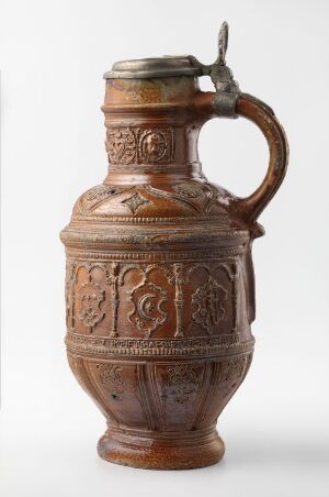  An ornate, bulbous earthenware jug with a hinged metal lid and decorative relief patterns, featuring a reddish-brown color palette set against a light background.