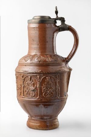  A traditional brown stoneware beer stein with a metal lid, featuring intricate relief designs, set against a light background.