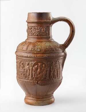  A historical stoneware jug titled "De åtte barmhjertighetsgjerninger" by an unknown artist, with a warm terracotta brown tone and intricate relief decorations depicting acts of mercy around its bulbous body, and a glossy finish from salt glazing. The jug has a sturdy handle, and it stands against a neutral background.